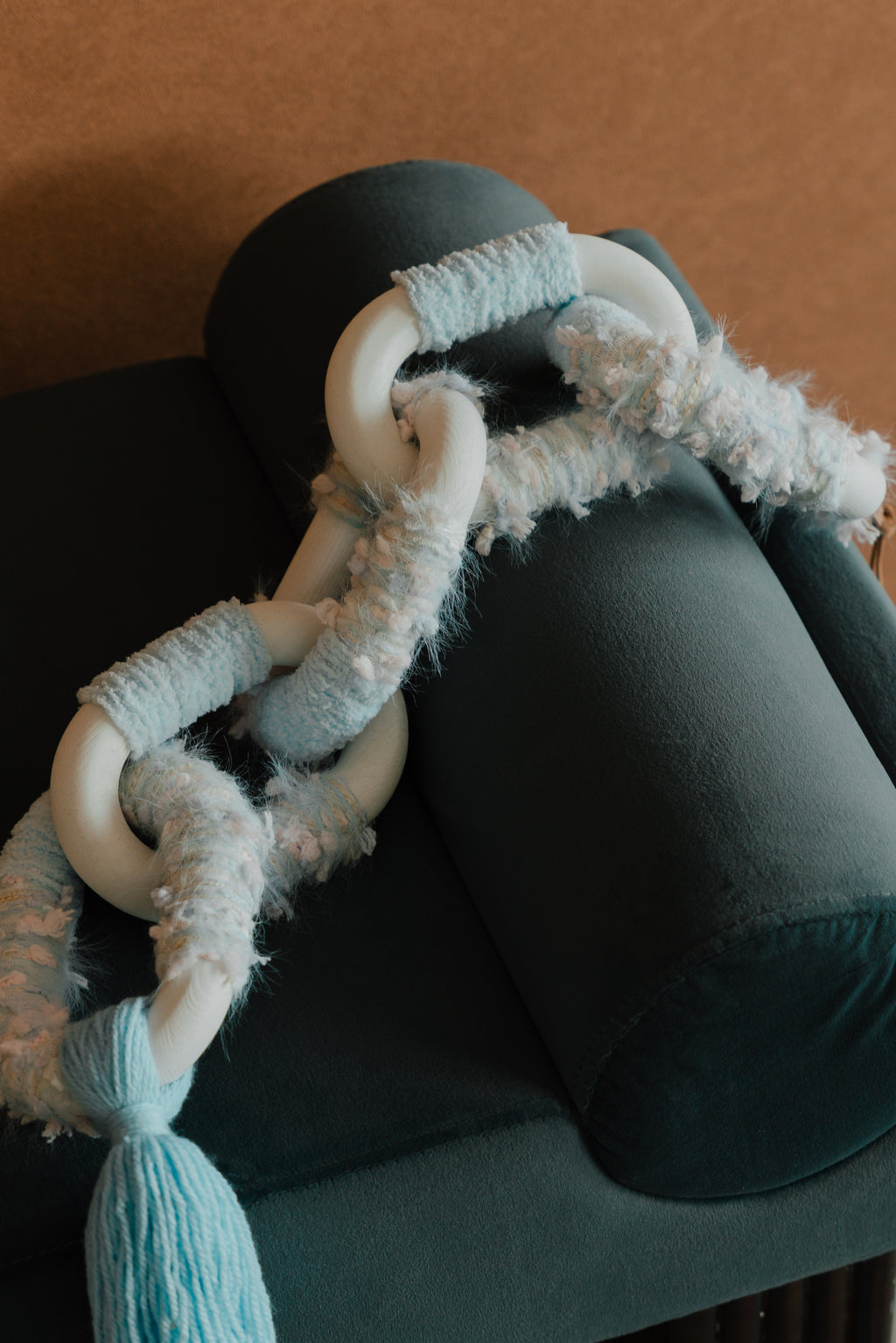 Close-up of Passing By Blooms Delphinium: layered purple yarn and stitched leather forming delicate, blooming texture.