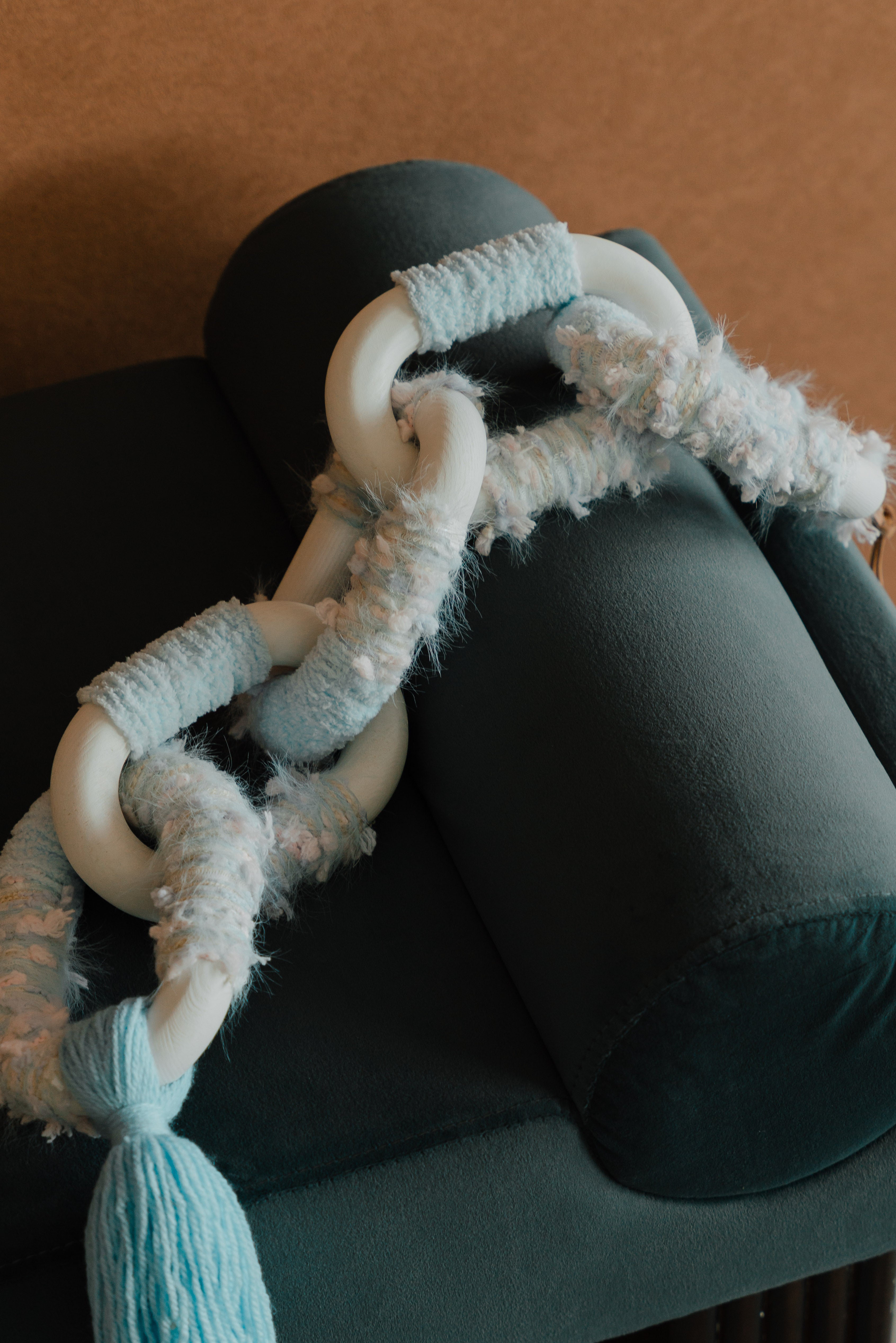 Close-up of Passing By Blooms Delphinium: layered purple yarn and stitched leather forming delicate, blooming texture.