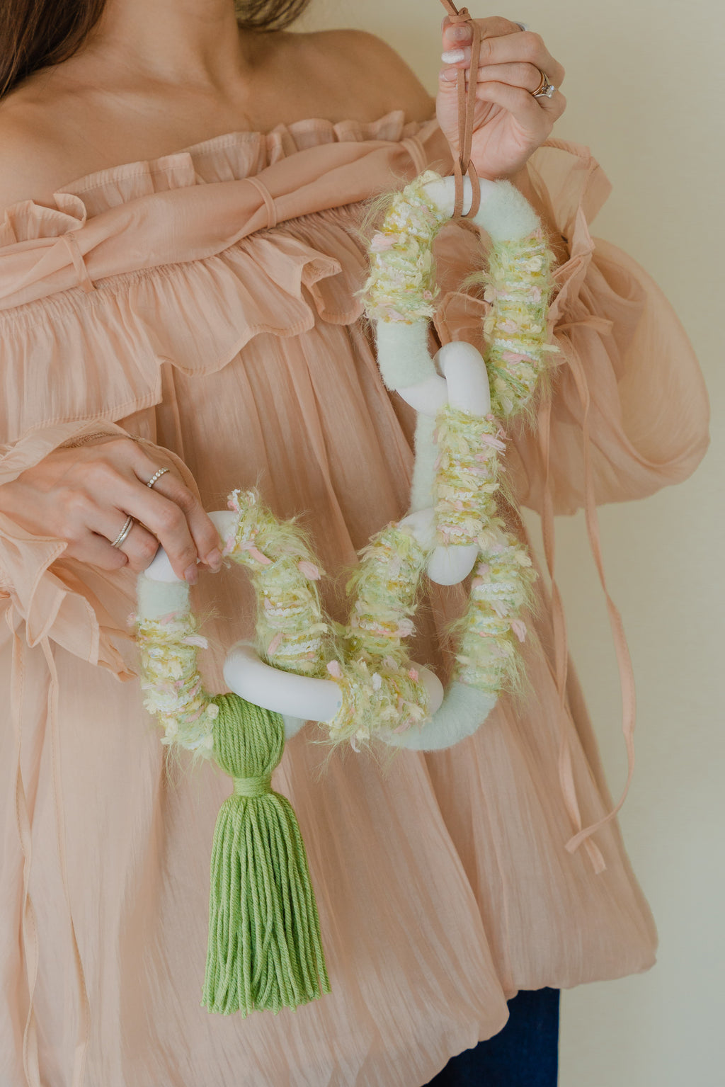 Detail of the Passing By Blooms Valley fibre art — leafy yarn patterns and subtle leather stitching create an elegant, nature-inspired texture.