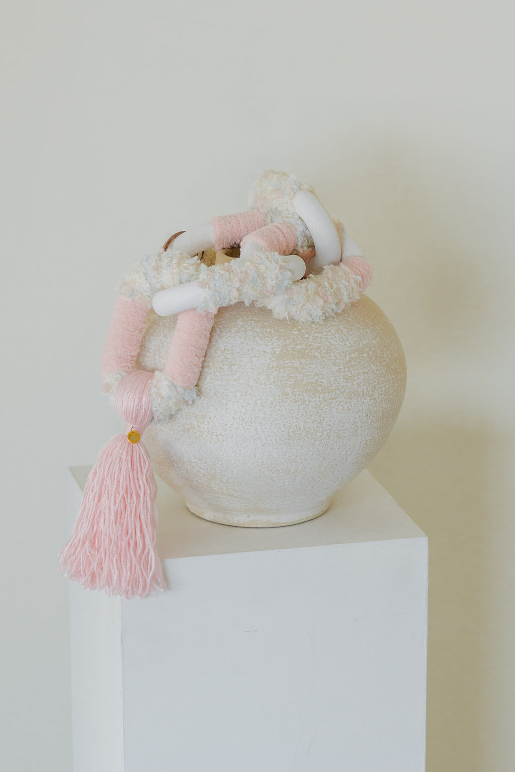 Passing By Blooms Rose fibre wall art — soft rose-pink and cream yarn woven with leather, evoking a gentle field of blooming petals.