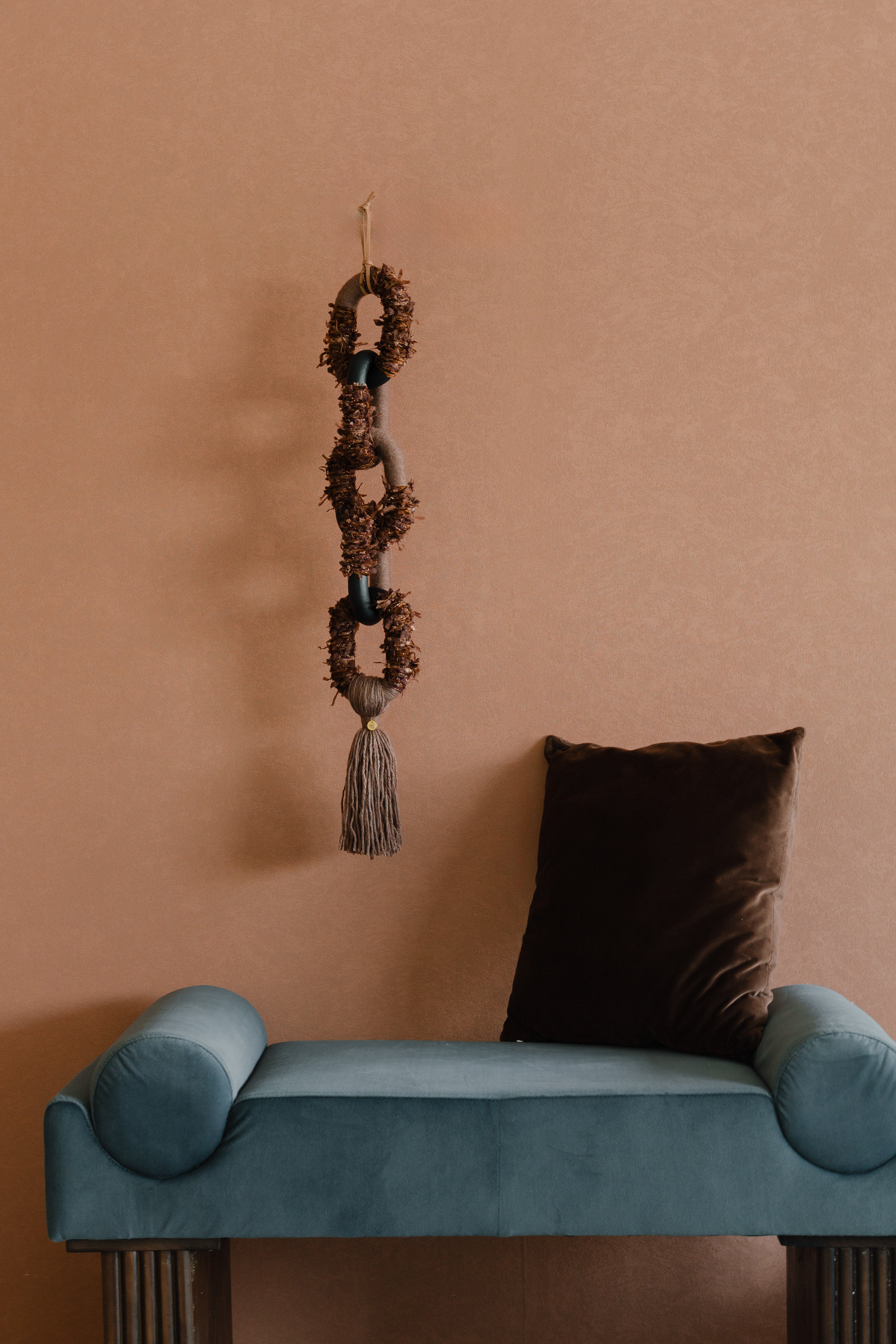Passing By Blooms Mocha fibre wall art — warm mocha and cream yarn woven with leather accents, evoking a soft, trailing floral field.