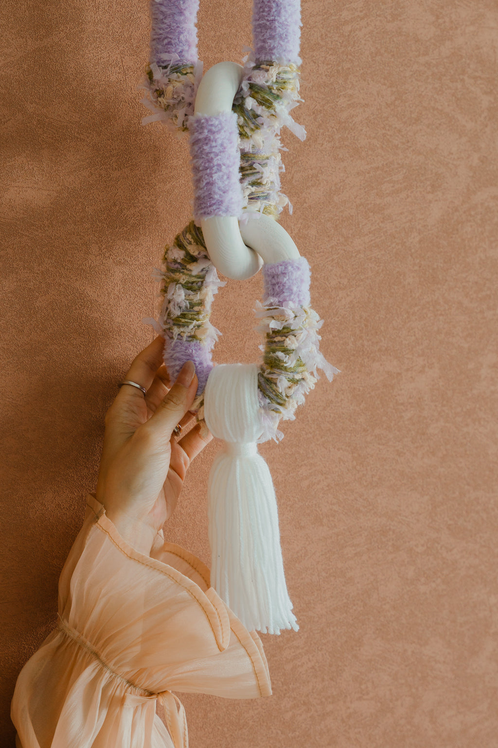 Passing By Blooms Valley Wisteria hanging in a serene living room, its purple-blue texture adding natural softness to a neutral wall.