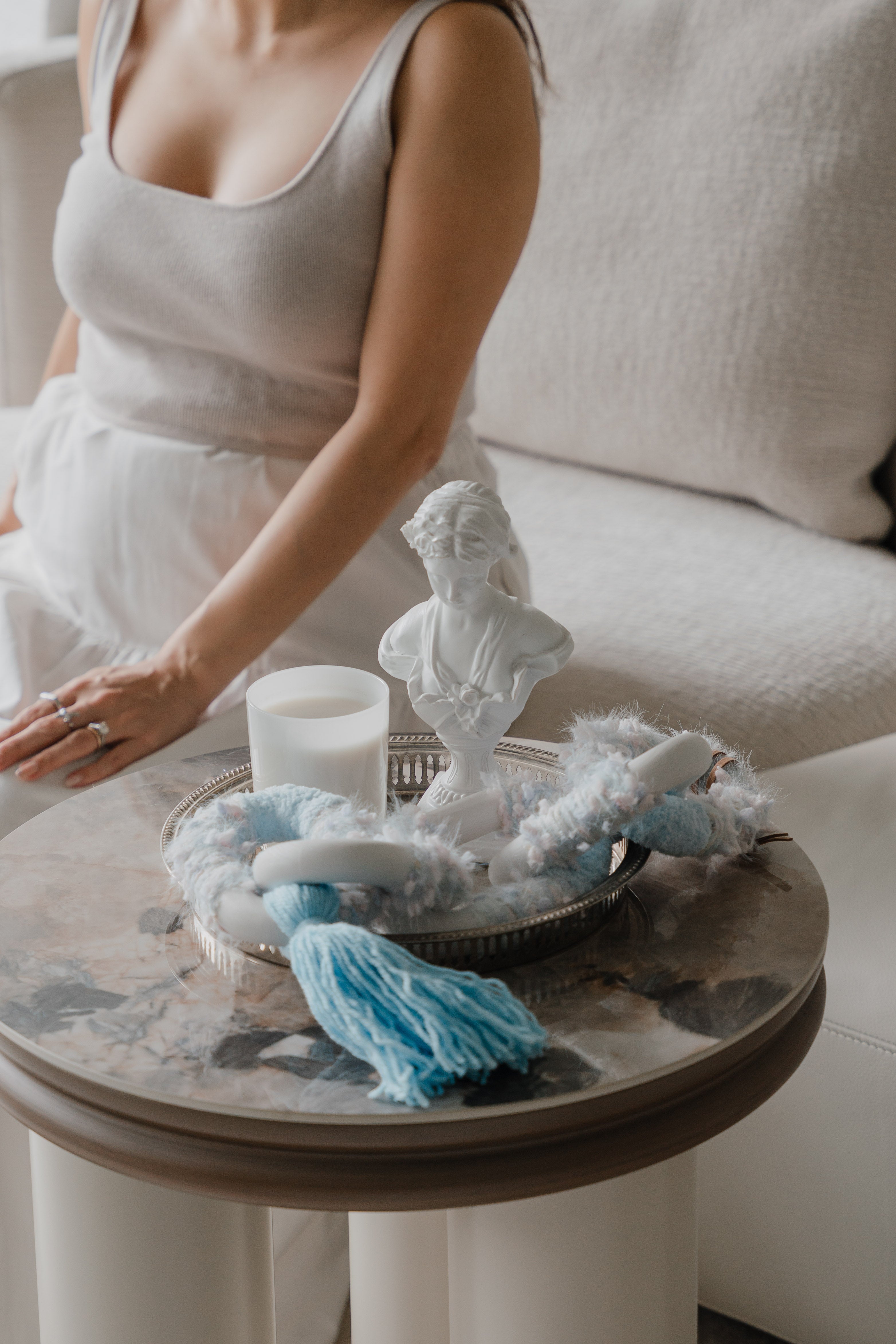 Passing By Blooms Delphinium textile piece resting on a chic tray, its lavender and blue threads bringing delicate texture to a curated coffee table setting.