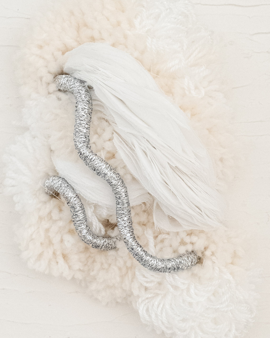 Close-up of Cocoon N°4: layered natural wool texture creating an organic, wrapped design with subtle rope detailing.