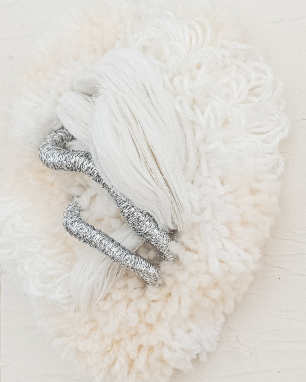 Side view of Cocoon N°2 wall hanging: its three-dimensional shape and rounded yarn structure create a sense of organic softness.