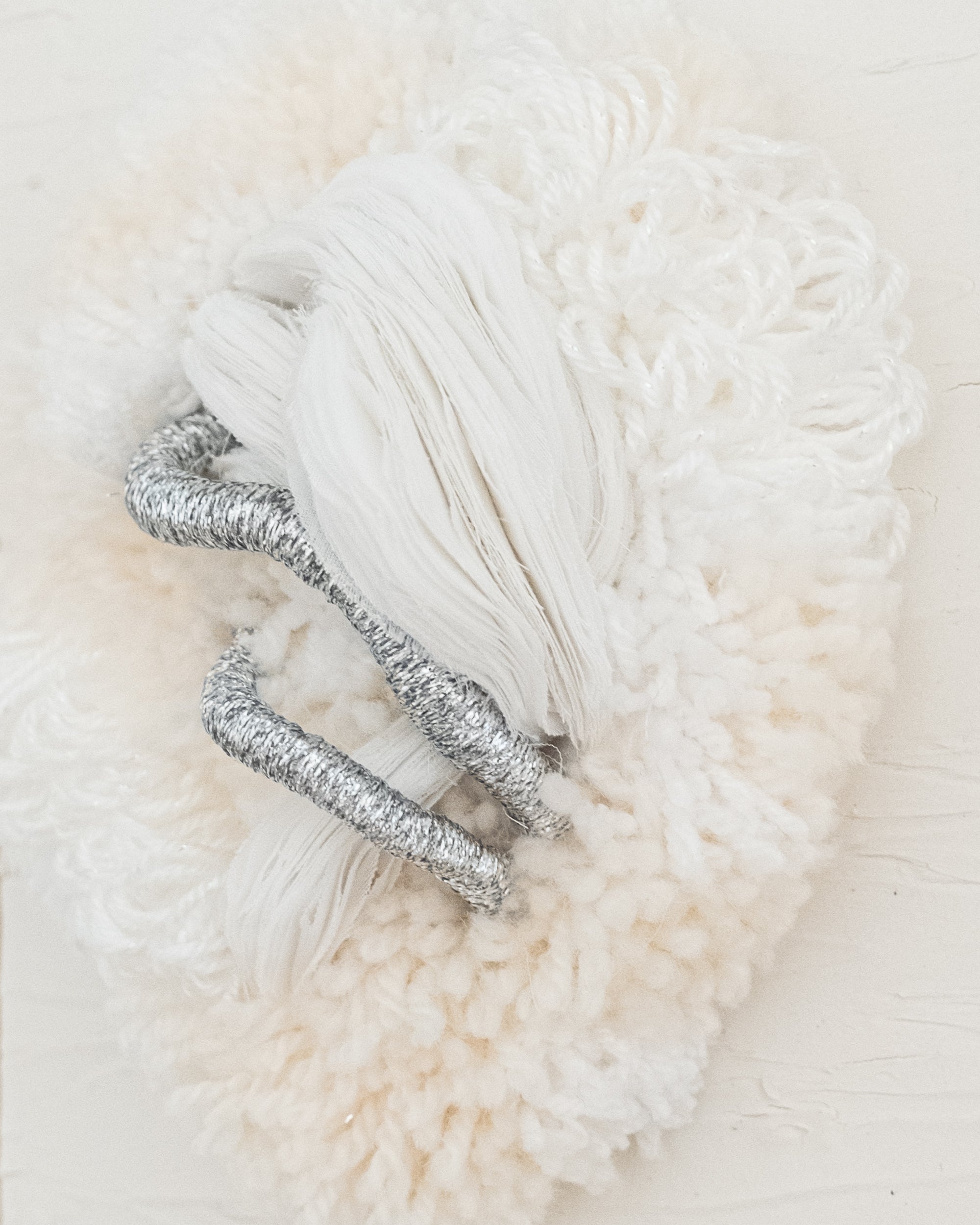 Side view of Cocoon N°2 wall hanging: its three-dimensional shape and rounded yarn structure create a sense of organic softness.