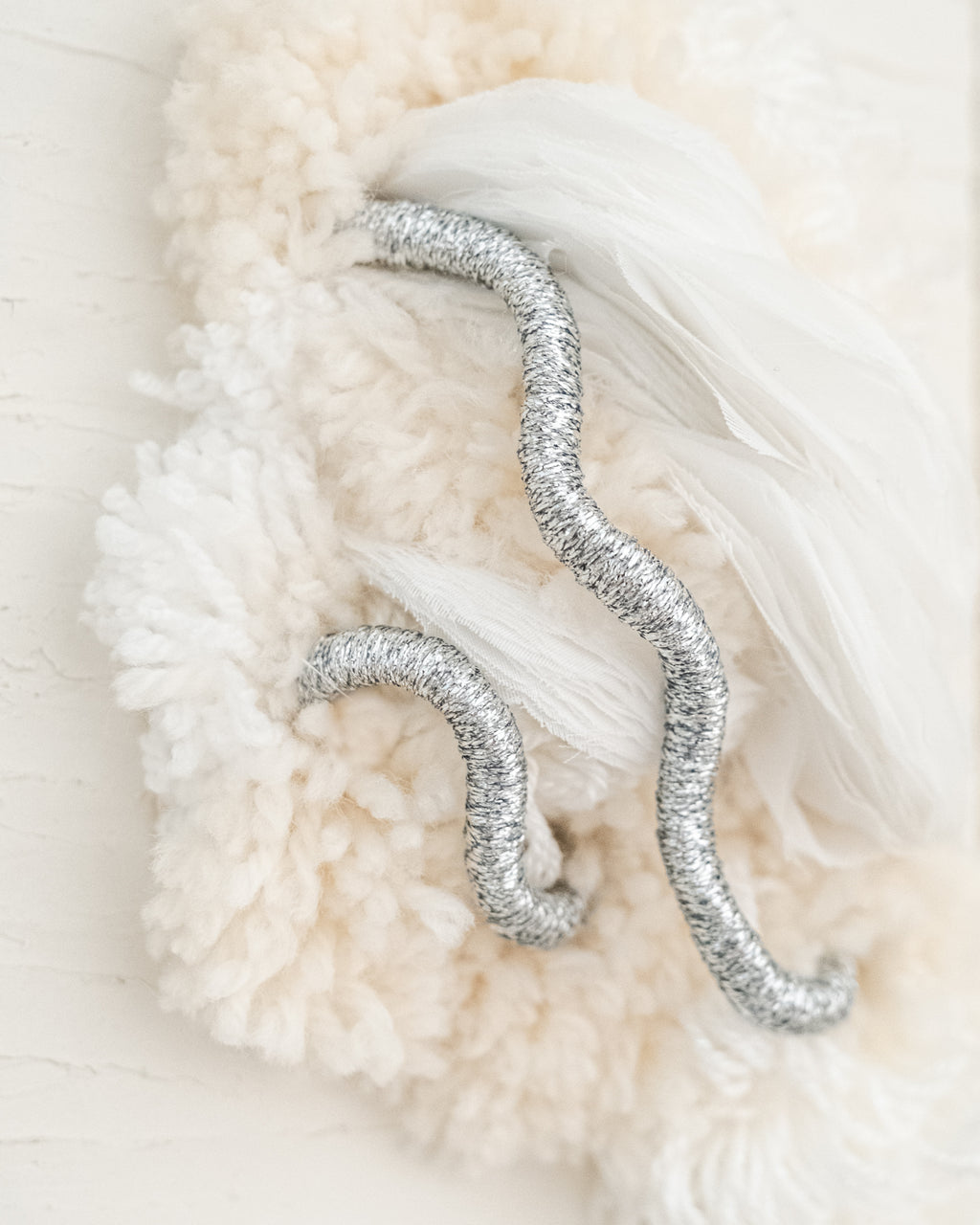 Side angle of Cocoon N°4 fibre sculpture, showcasing its three-dimensional shape and flowing, tactile fibers.