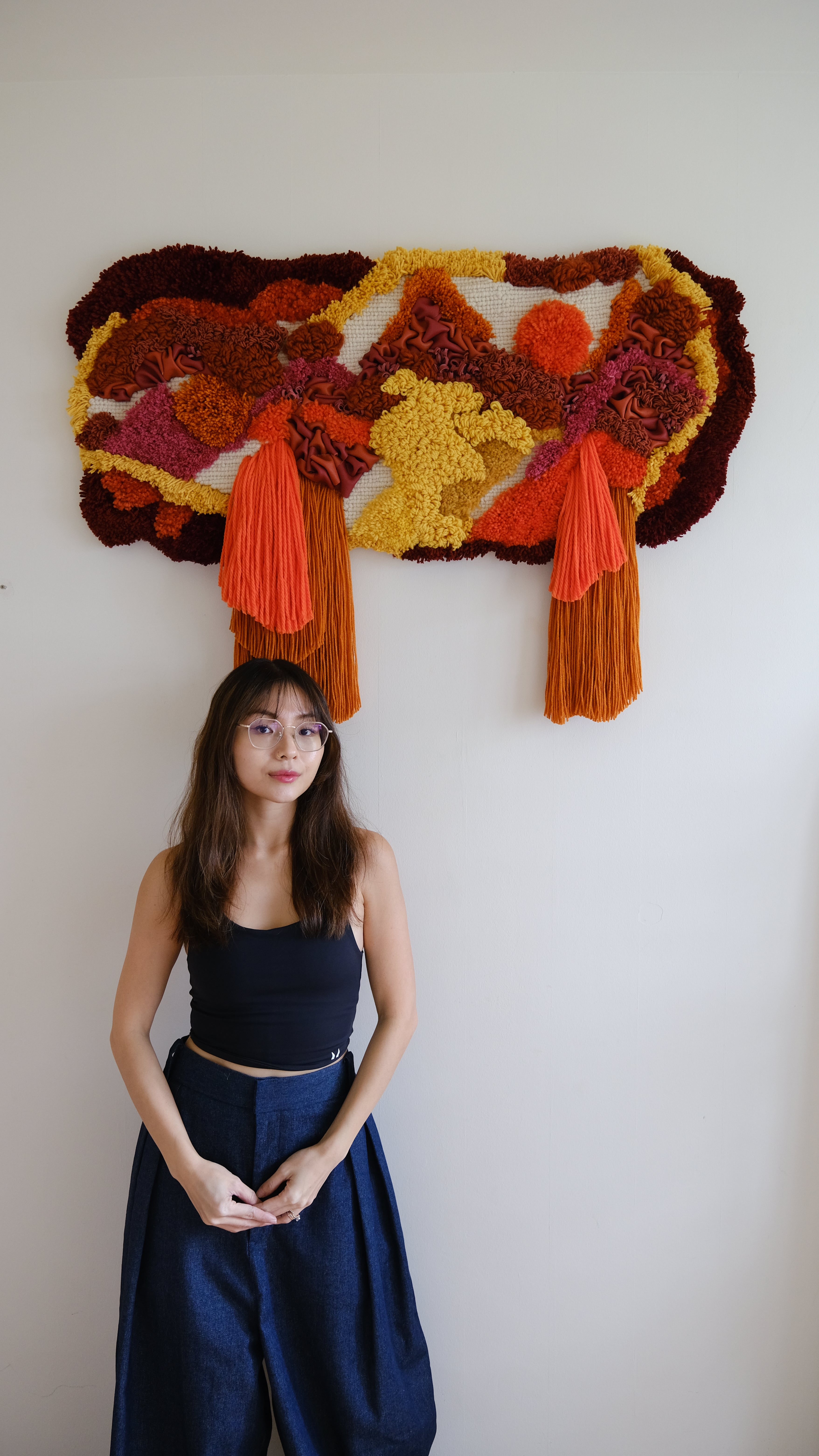 Handmade Ascend wall hanging: wool and acrylic yarn in sunrise tones, interwoven with leather, minimalist landscape-inspired decor.