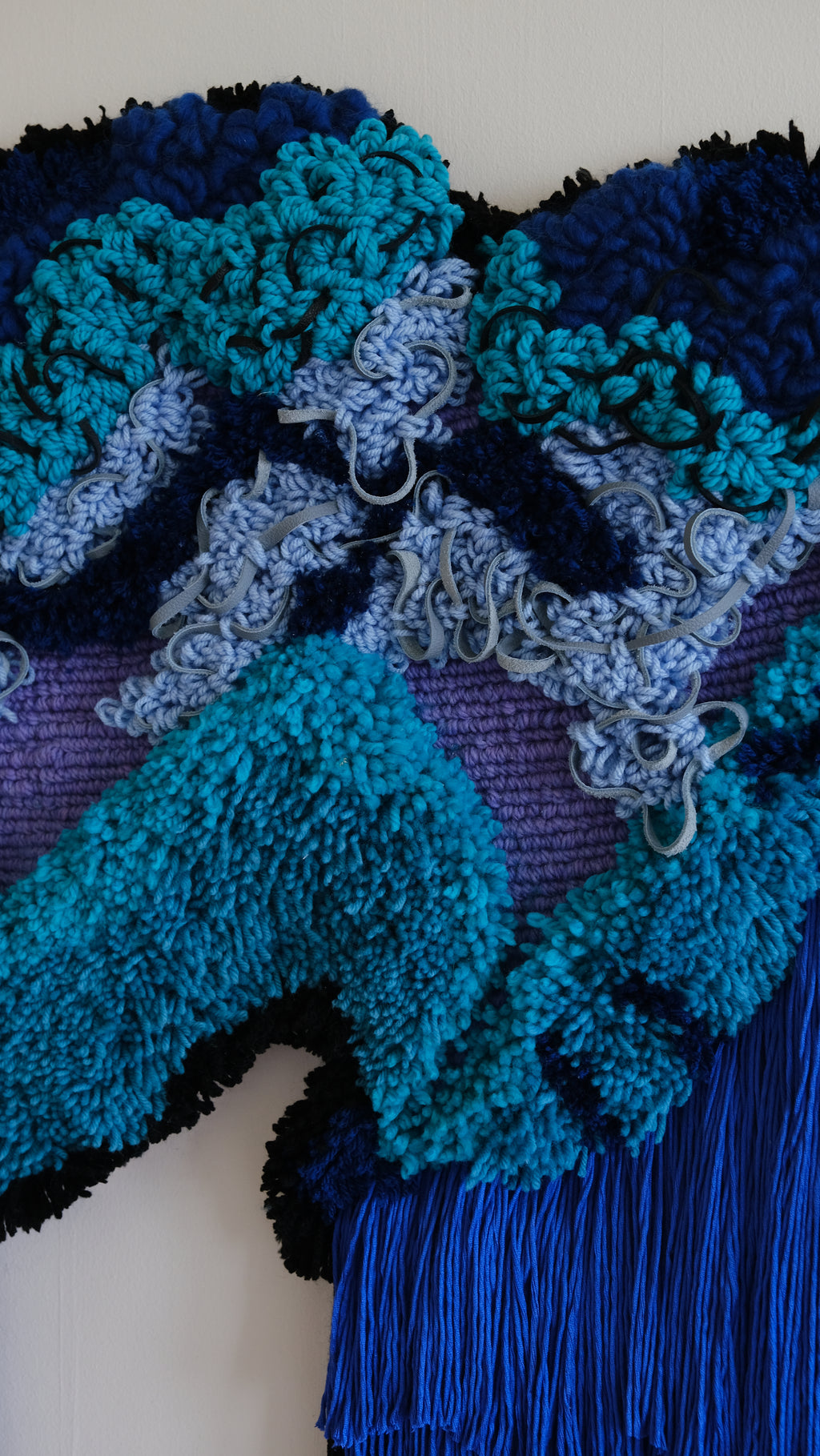 Bespoke fibre art ‘Cascade’: textured threads in blue and violet shades cascade like a serene waterfall, blending natural rhythm with artisanal detail.