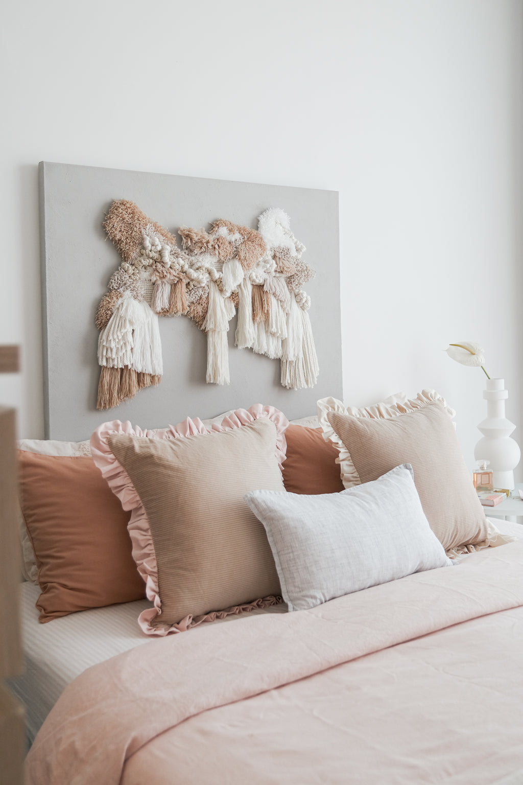 Kind Words Rosewater Cushion styled with neutral pillows — subtle color pop in bedroom.