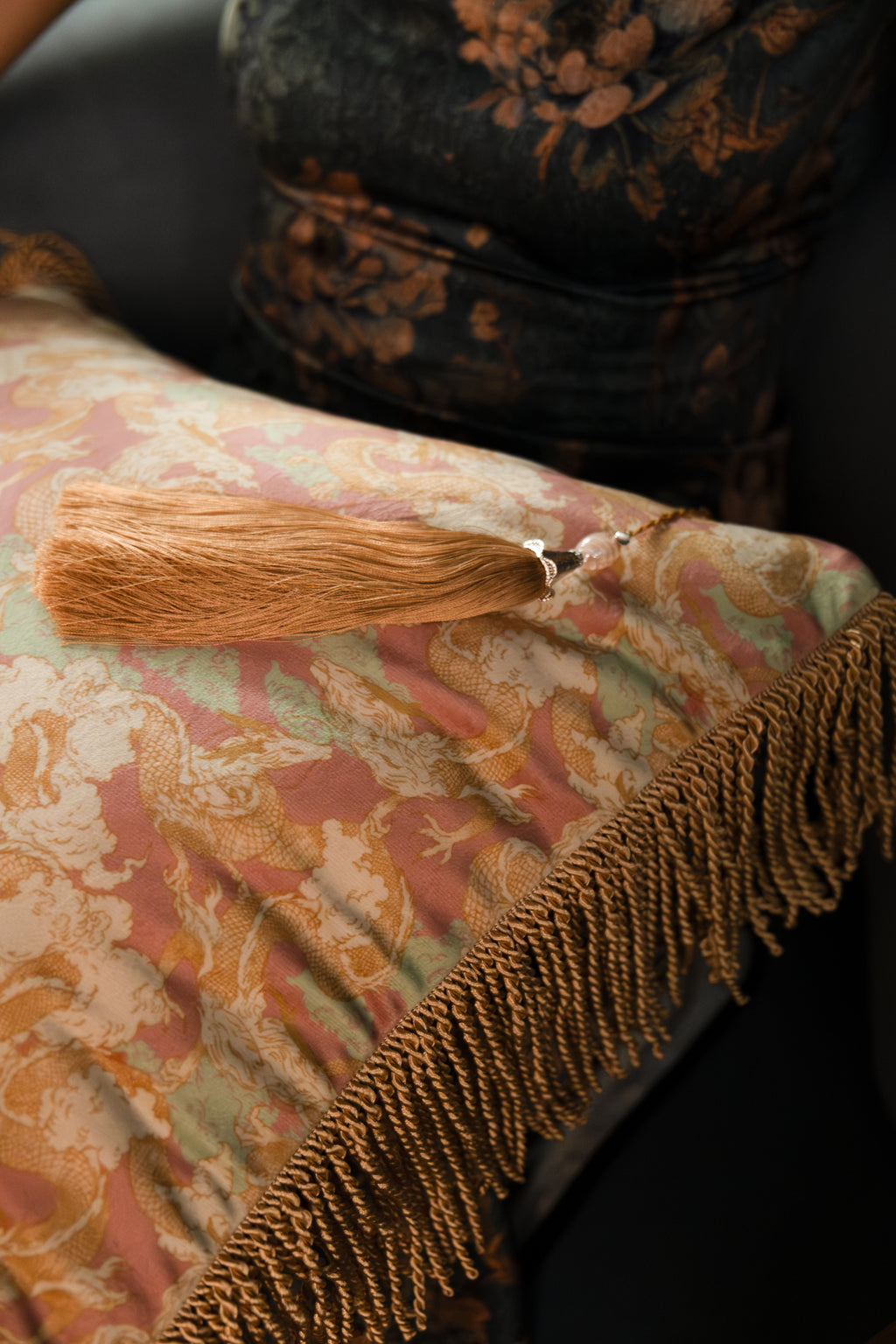 Side view of Dragon Dreams cushion, showing its soft, sculptural textile form and luxurious dragon design.
