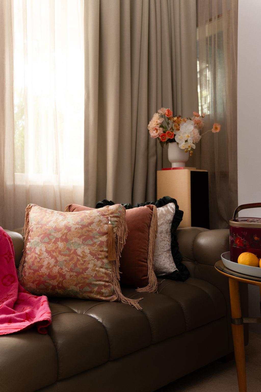 Lifestyle view of Dragon Dreams cushion arranged on a couch — ornate teal and gold dragon artwork, velvet back, and fine silky tassels