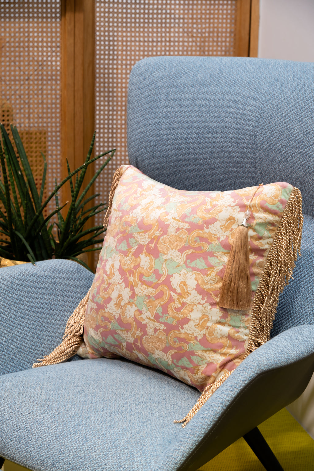 Dragon Dreams decorative pillow on a sofa, its elegant teal and gold dragon design adding bold artistic flair.