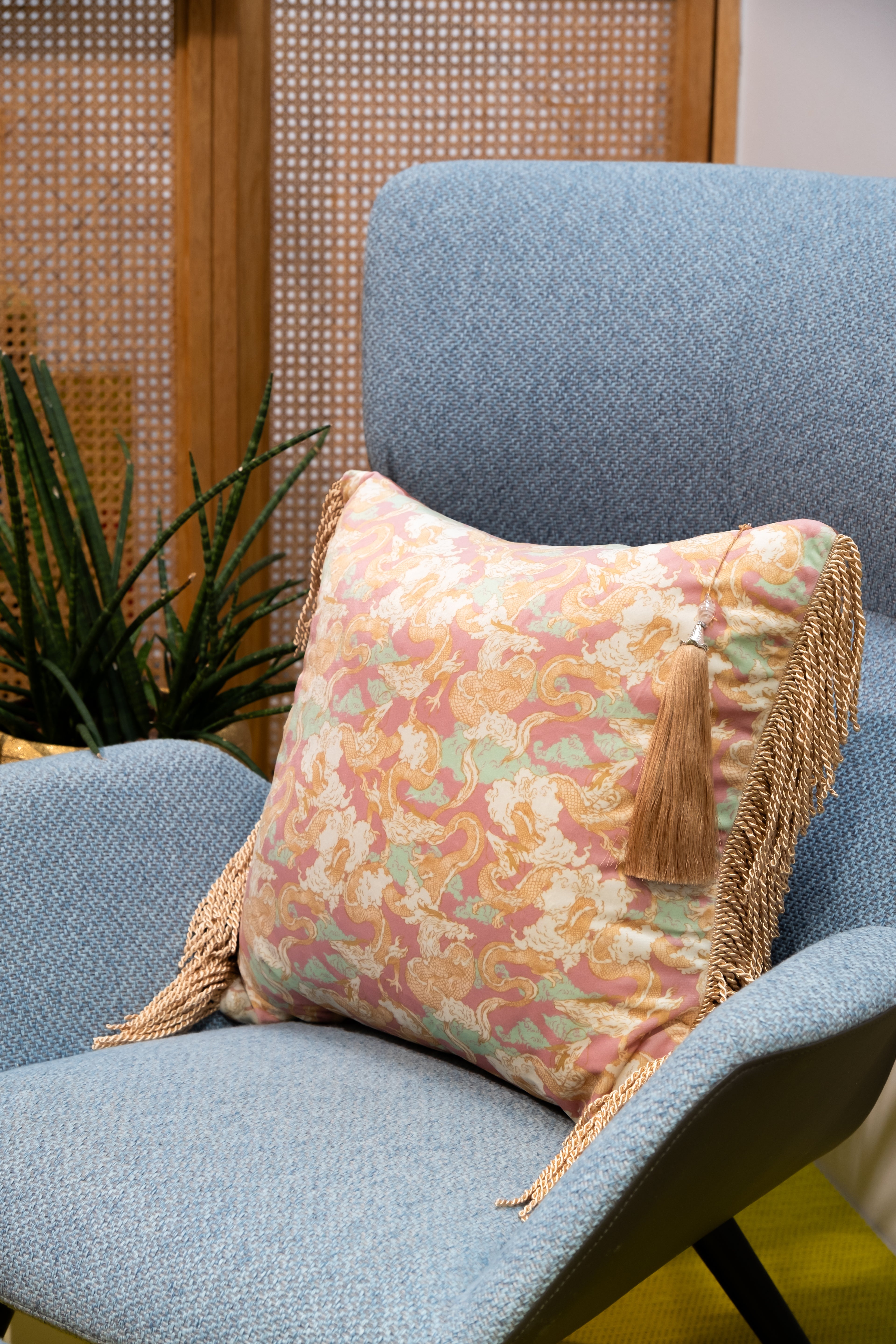 Dragon Dreams decorative pillow on a sofa, its elegant teal and gold dragon design adding bold artistic flair.