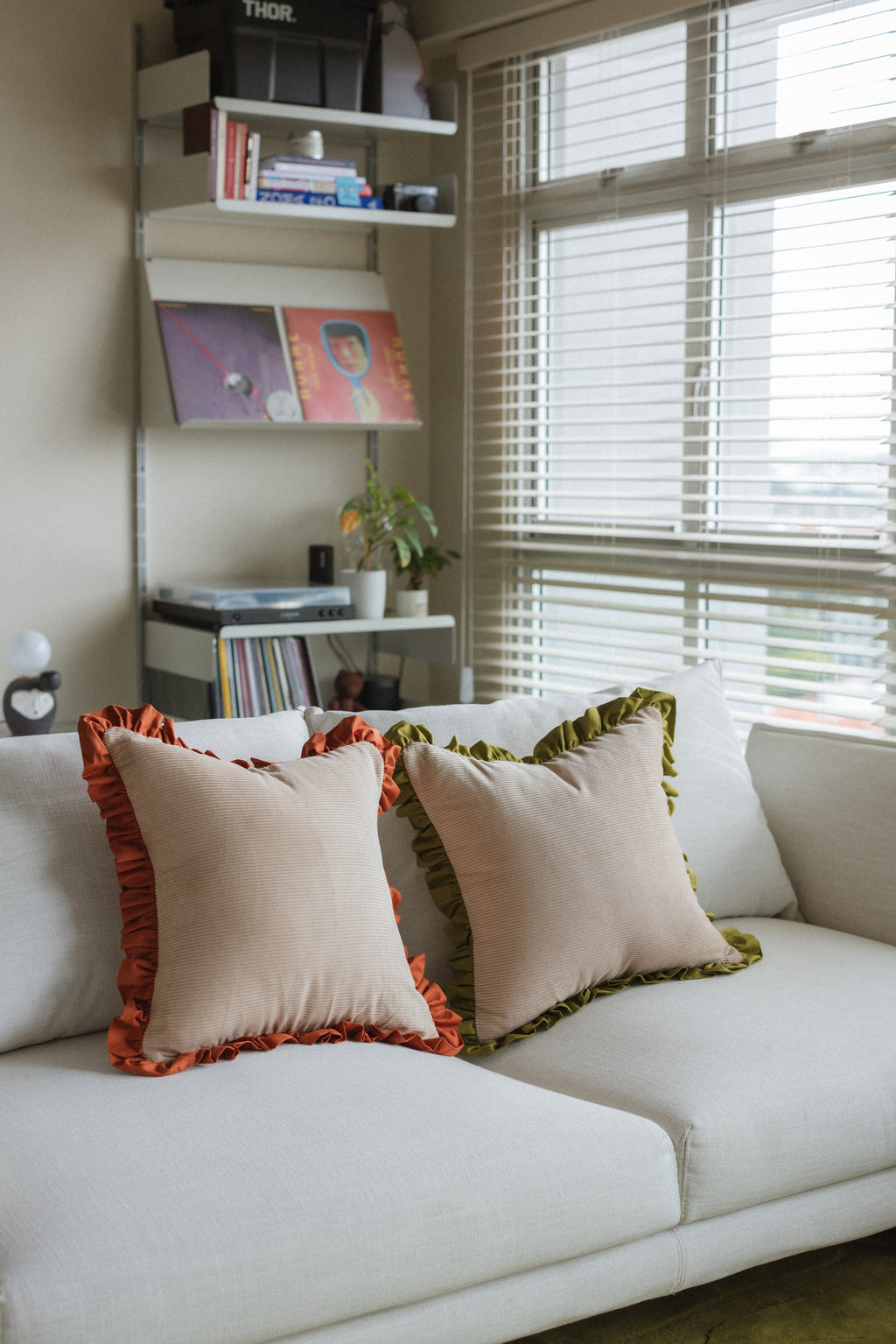 Decorative accent cushion Warm Hugs Rust cushion against light-colored sofa — elegant home décor piece.