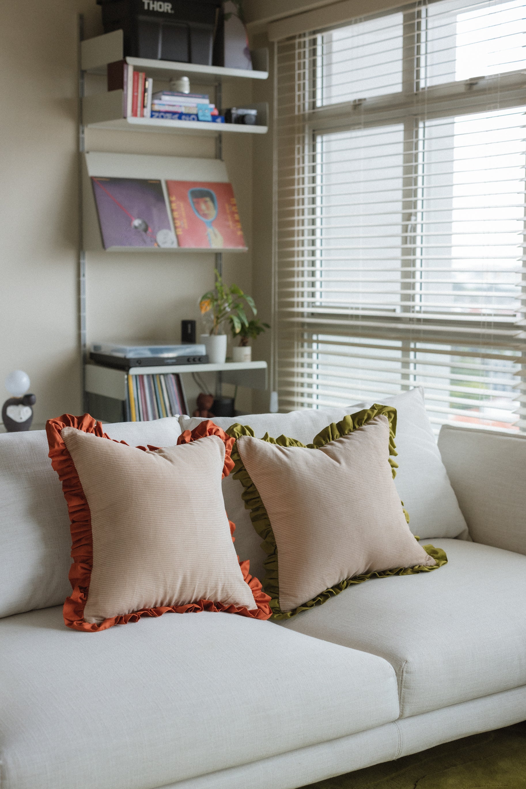 Decorative accent cushion Warm Hugs Rust cushion against light-colored sofa — elegant home décor piece.