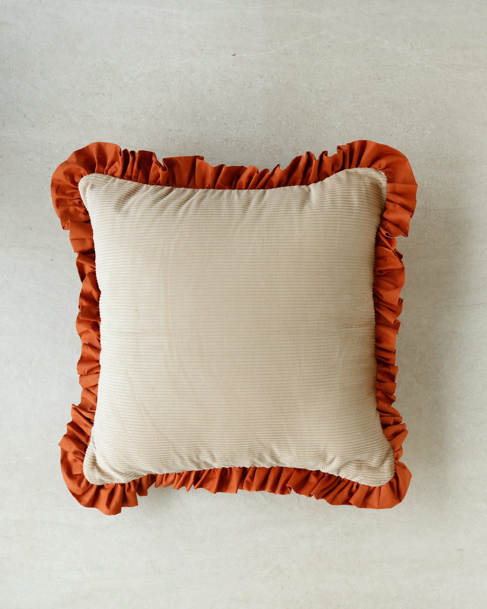 Close-up of Warm Hugs Rust Cushion fabric showing velvet pile and stitching details.