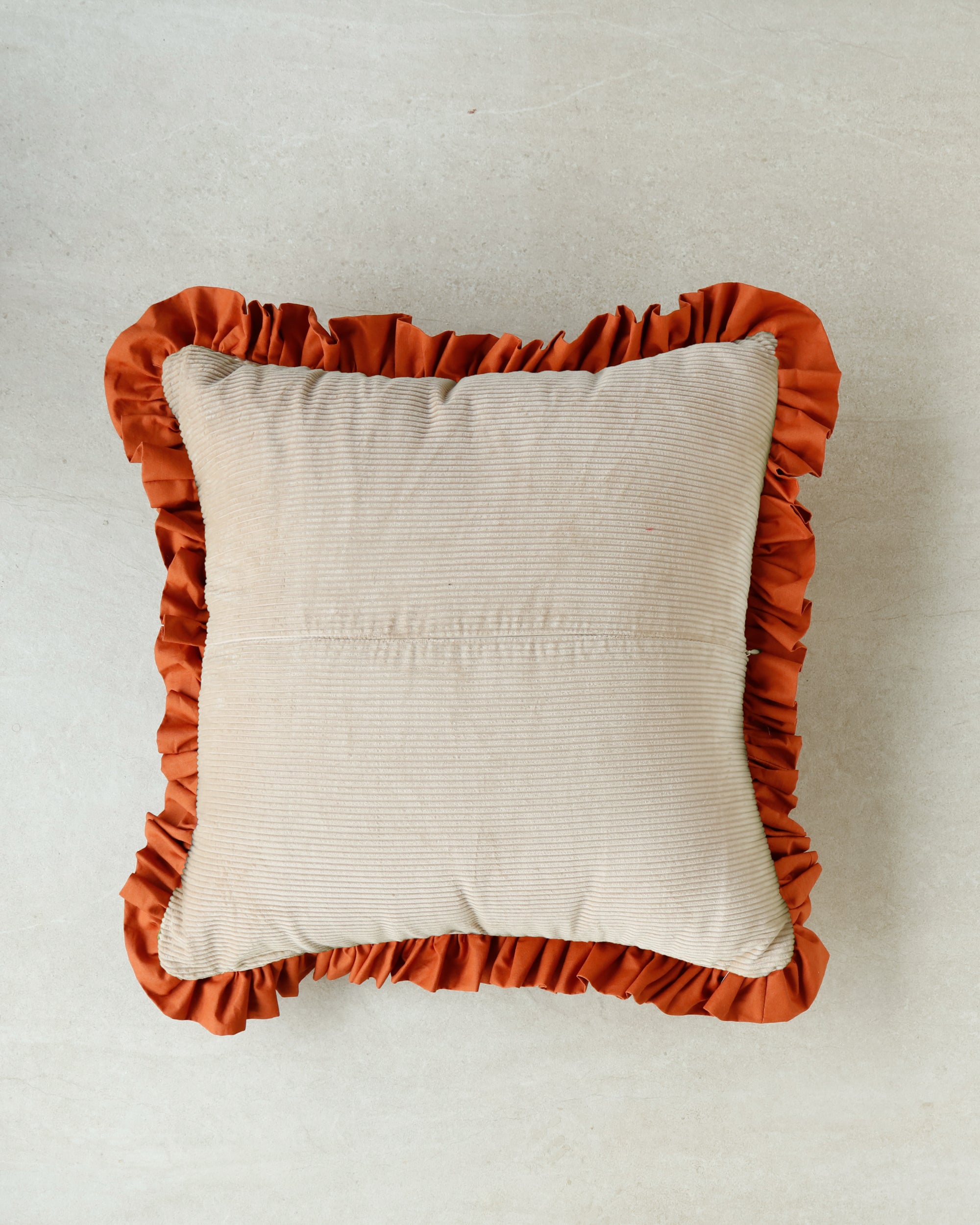 Minimalist product shot — Warm Hugs Rust Cushion isolated on white background.