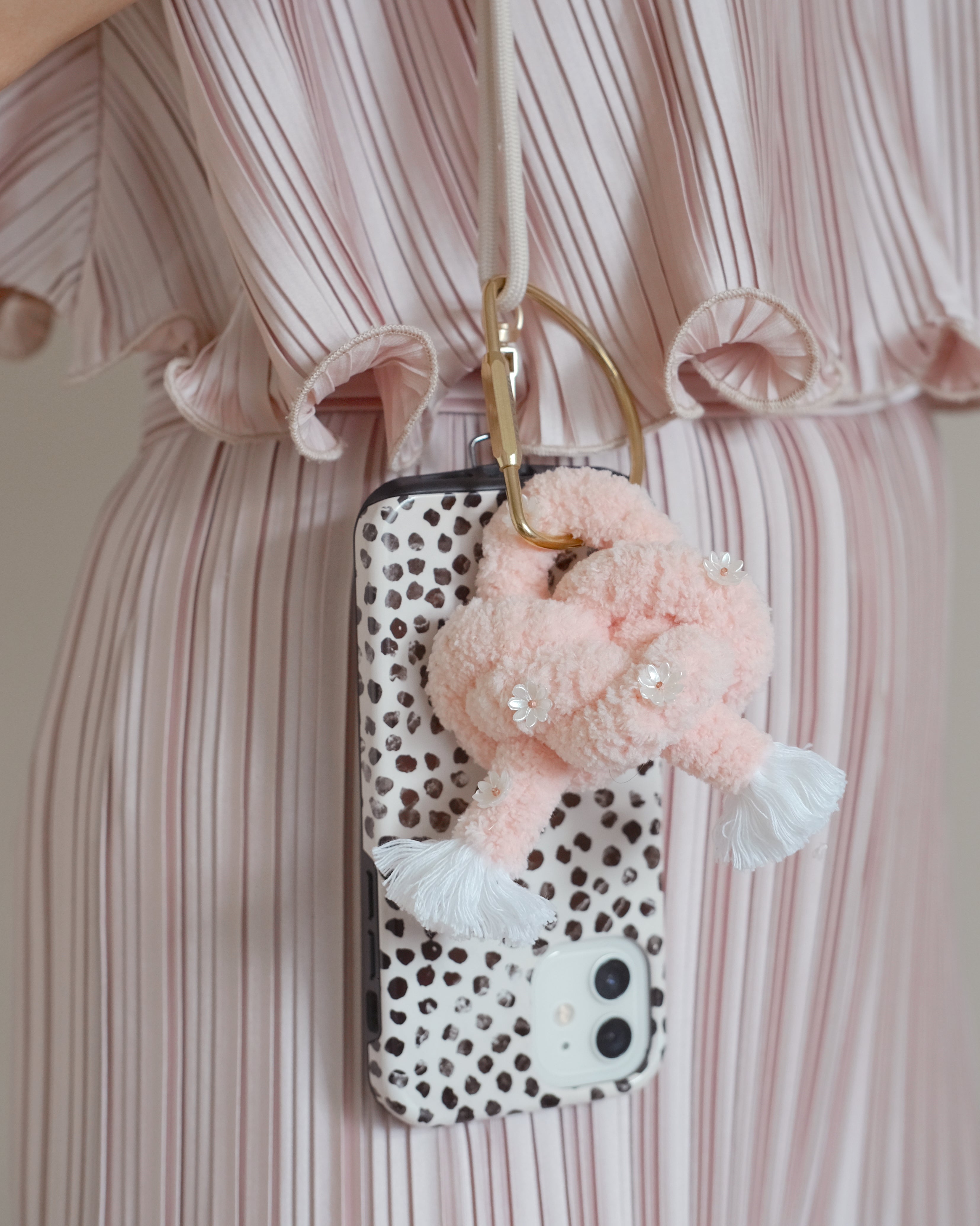 Flamingo Ethereal keychain accessory attached to a handbag, featuring a graceful pink flamingo and gold hardware.