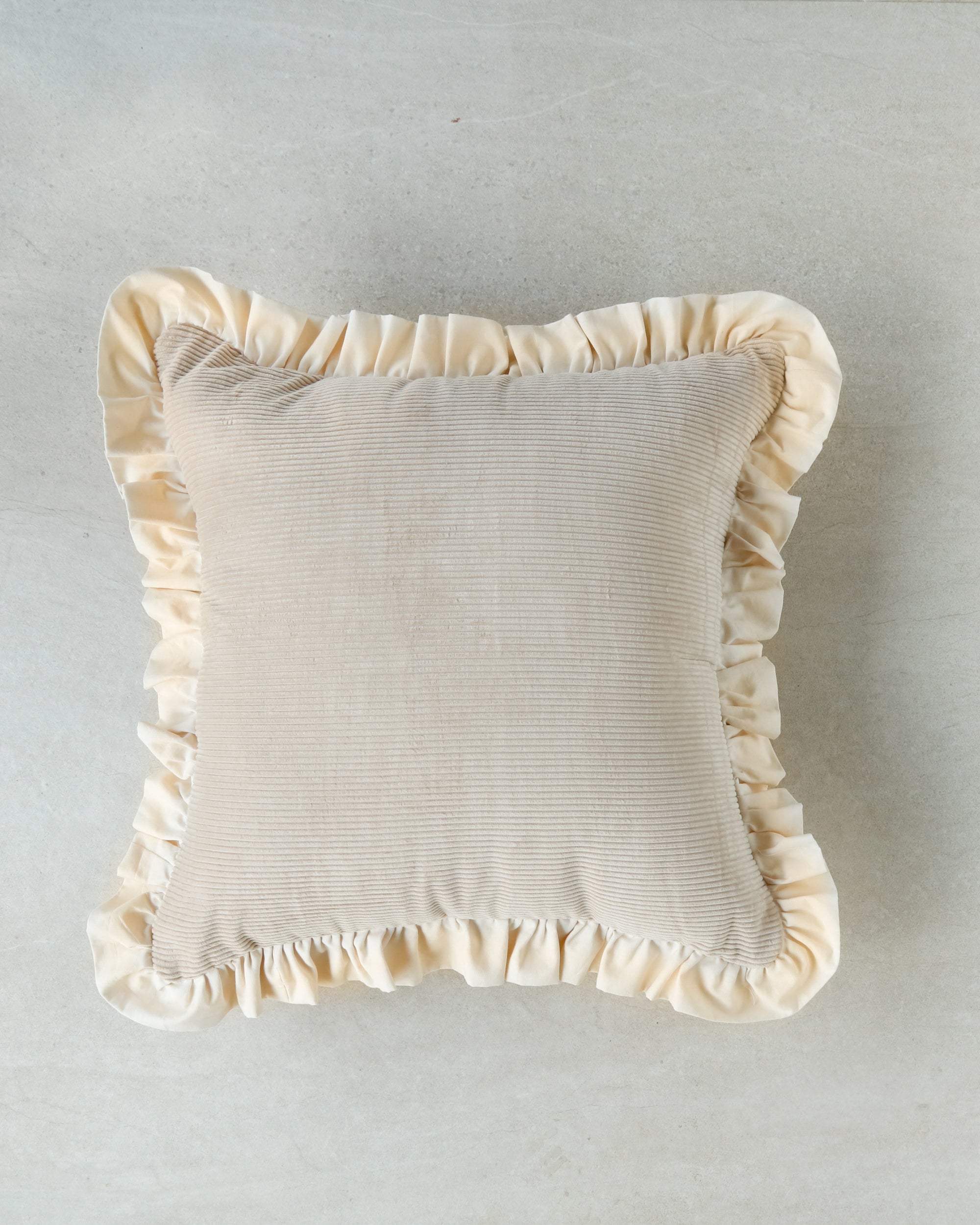BeeYarnd Gentle Touch cushion in soft light peach velvet-style fabric on neutral background.